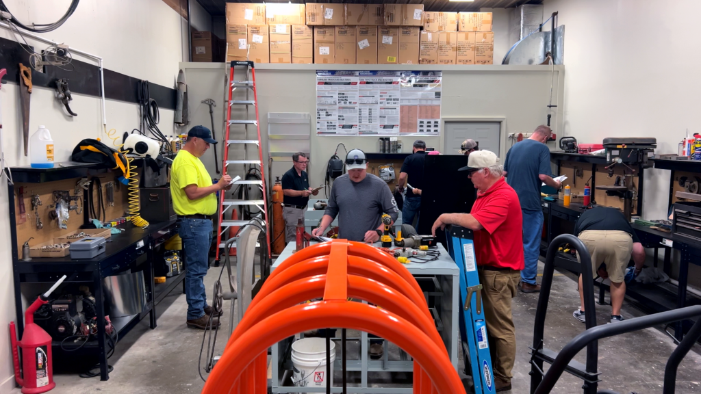 ResponsibleAg auditor trainees with clipboards inspect a mock maintenance shop for safety issues during a hands-on training exercise.